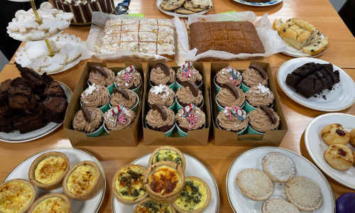 Bake Sale table spread with a variety of cakes, quiches and pies 