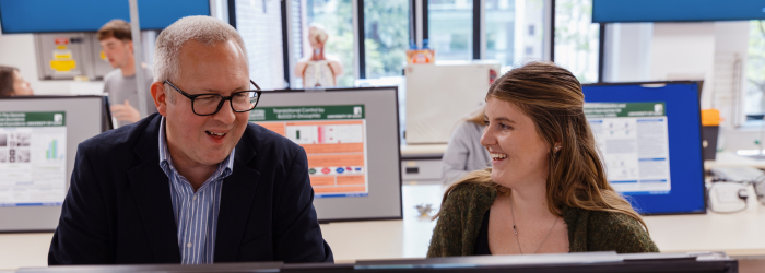 Dr Andrew Pridmore discussing poster with student at the University of Leeds University of Leeds prize ceremony.